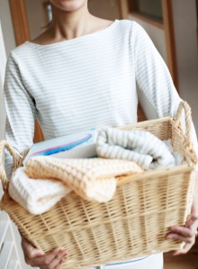Woman Holding Laundry Basket Full of Towels